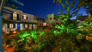 Un patio con plantas en macetas y un espacio exterior bien iluminado de noche.