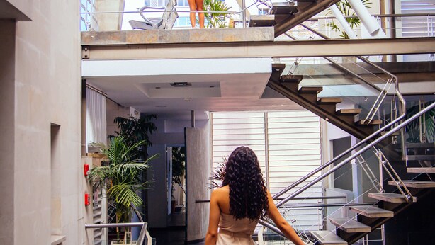 A modern indoor space with a glass staircase, metal railings, and a high ceiling. - Hotel Plaza Las Americas Cali (Cali)