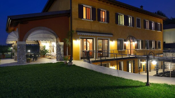 A two-story building with a patio area, outdoor seating, and a pool. - Agriturismo Bacche di Bosco (Verona)
