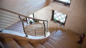 A spiral staircase with metal railings and a small window with plants. - Agriturismo Bacche di Bosco (Verona)