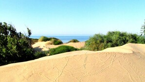 A sandy beach with dunes and sparse vegetation. - Casa Vacanza Ondablu (Ispica)