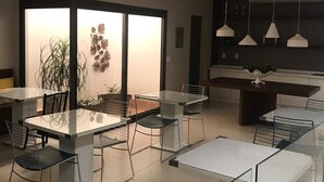 A modern dining area with a glass partition, a central table, and chairs. - Ventura Hotel (Barreiras)