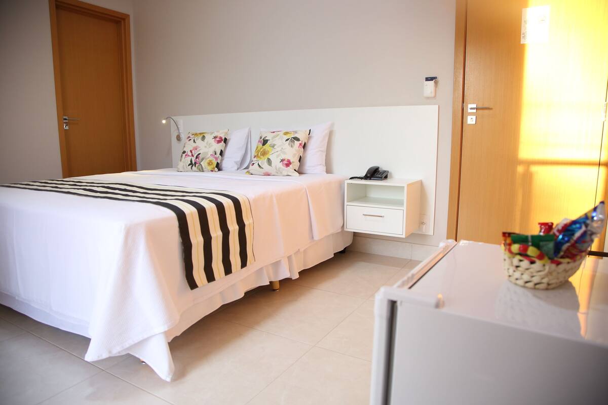 Ein Hotelzimmer mit Bett, Nachttisch und kleinem Tisch mit Korb.