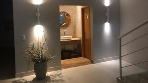 A modern hallway with a potted plant, a sink, and a mirror in a bathroom. - Ventura Hotel (Barreiras)