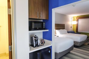 A hotel room with a bed, a desk with a microwave, a coffee maker, and a mini-fridge. - Holiday Inn Express & Suites Houston IAH - Beltway 8 by IHG (Houston)