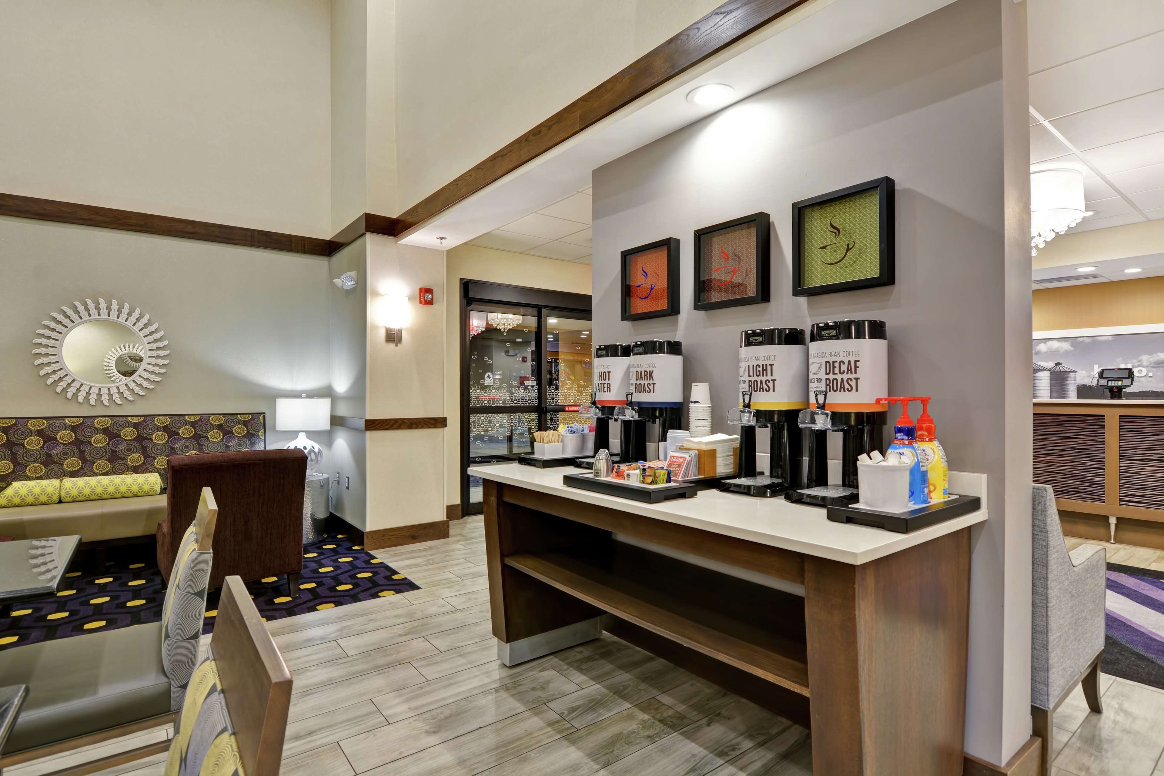 Een hotellobby met een receptiebalie, een zithoek en een koffiehoek.