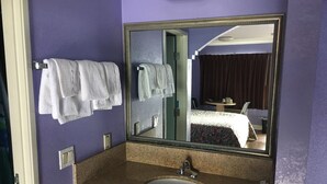 Ein Badezimmer mit Waschbecken, Spiegel und Handtüchern.