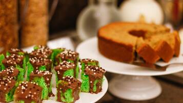 Un plato con postres verdes y de chocolate, además de un pastel sobre una servilleta blanca.