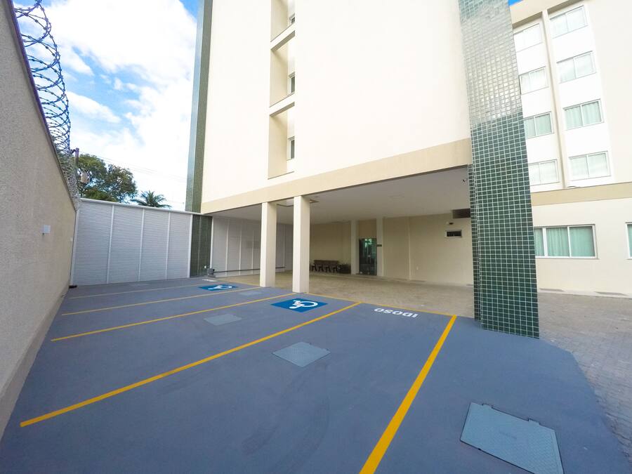 A parking area with blue handicap parking spaces and a building with a tiled facade.