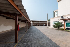 A covered walkway leading to a building with a sign reading "Hotel Jardins".