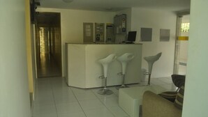 A modern kitchen with a central island, bar stools, and a refrigerator. - Pousada N S Fátima (Fortaleza)