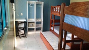 A small, compact room with a bunk bed, a desk, and a wardrobe. - Pousada N S Fátima (Fortaleza)