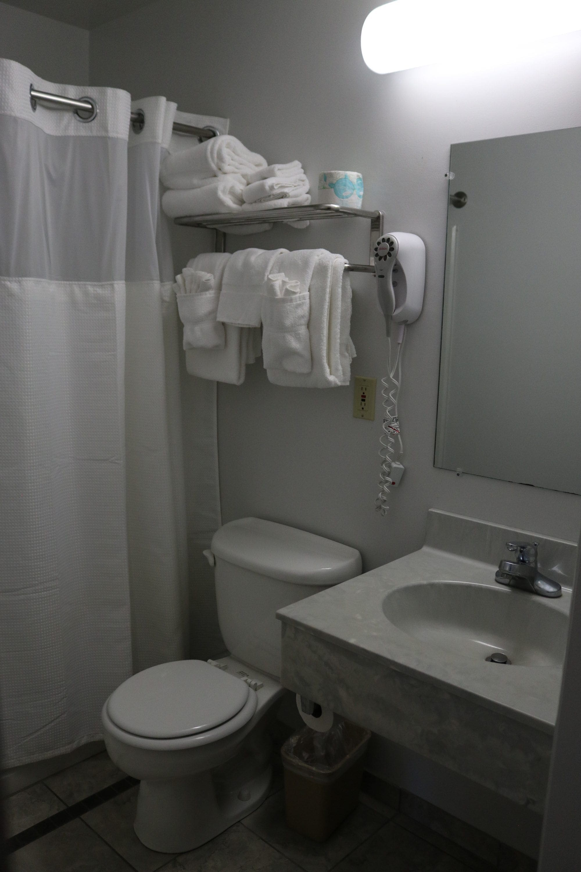 Ein Badezimmer mit Toilette, Waschbecken und Handtuchhalter.