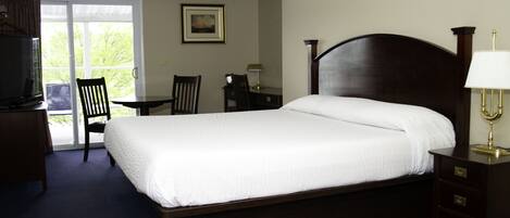 Une chambre d’hôtel avec un grand lit, un bureau, une chaise et un téléviseur.