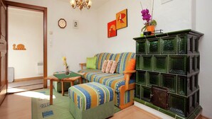 A cozy living room with a striped sofa, a green cabinet, and a chandelier. - Apartment in Stuhlfelden near Ski Lift (Stuhlfelden)