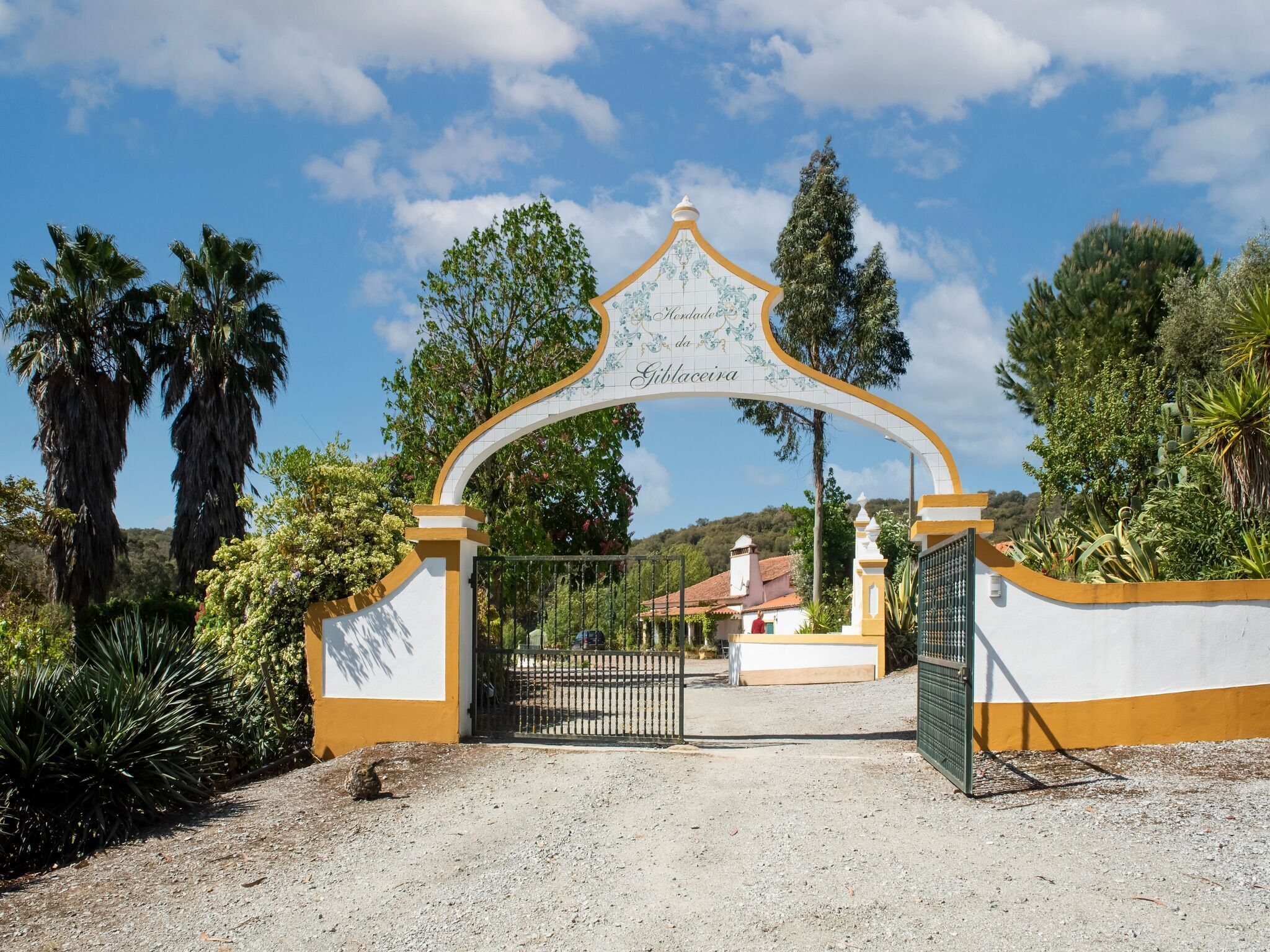 A gated entrance with a decorative archway and a sign reading "Gibaceira."