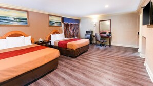 A hotel room with two beds, a desk, a television, and a mirror. - Pacifica Motel (Long Beach)