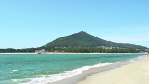 A beach with clear turquoise water, a sandy shore, and a forested hill in the background. - Countryside Cottage with Private Terrace (Gondufe, Ponte de Lima)
