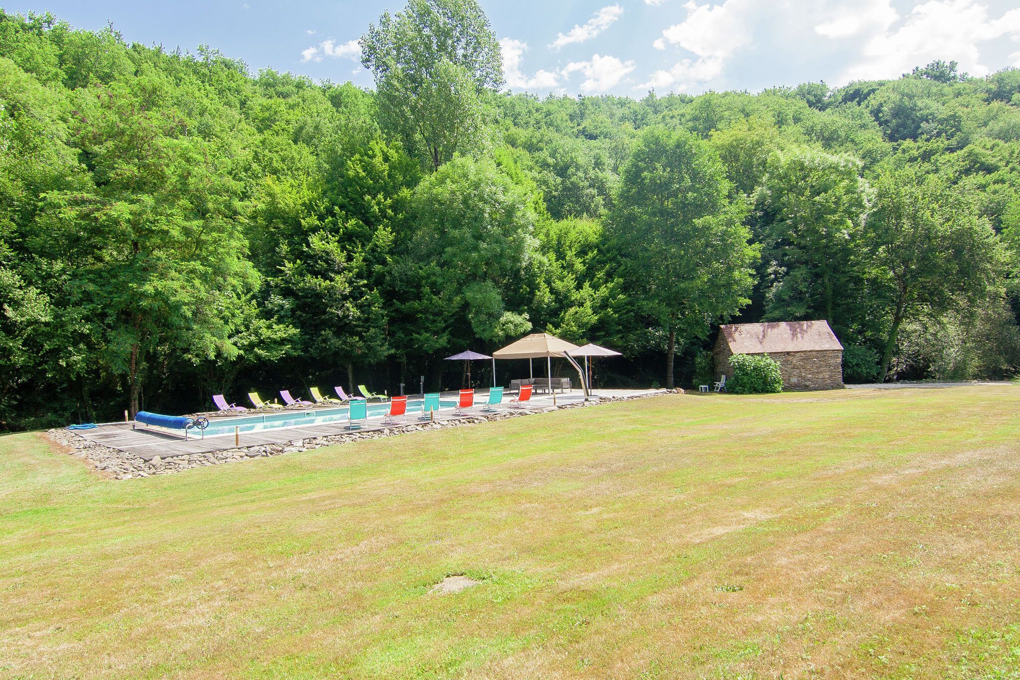 A pool area with lounge chairs and a gazebo.