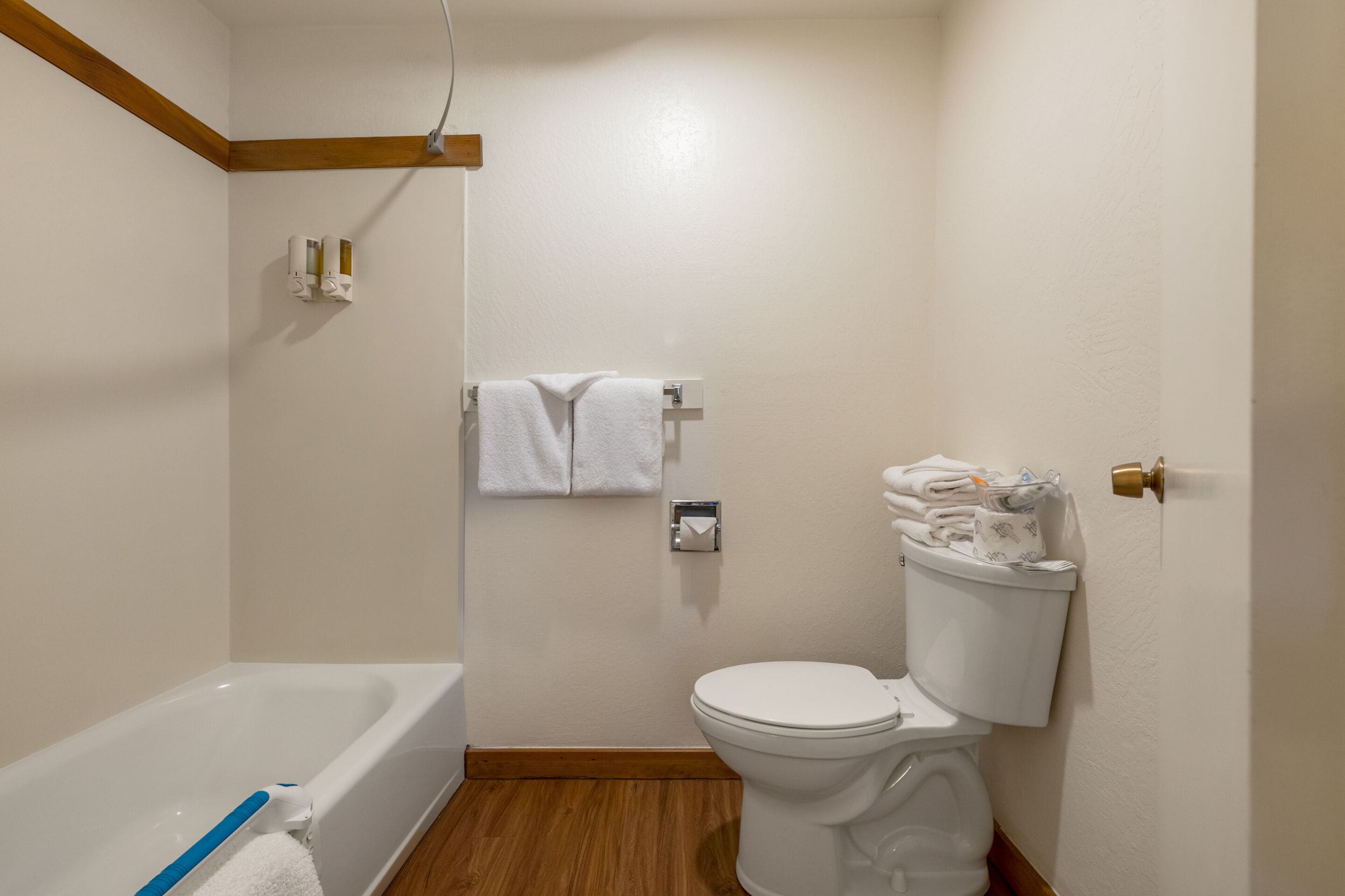 A bathroom with a bathtub, toilet, and towel rack.
