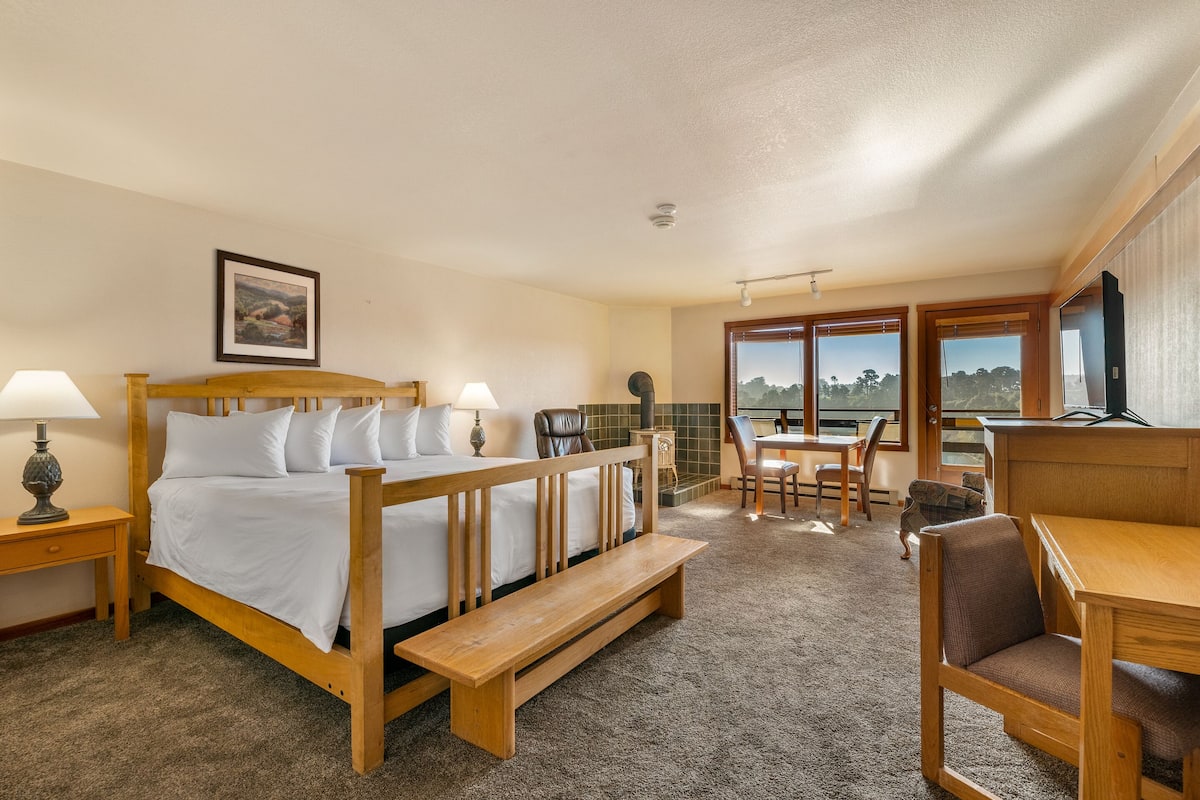 Una habitación de hotel con una cama de madera, un banco, un escritorio y una silla.