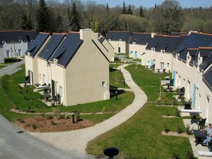Un quartier résidentiel comprenant plusieurs maisons, un sentier sinueux et des espaces aménagés pour se détendre en plein air.