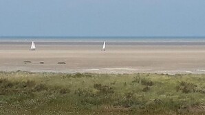 Una platja amb dos velers a l'aigua.