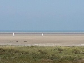 Ein Strand mit zwei Segelbooten auf dem Wasser.