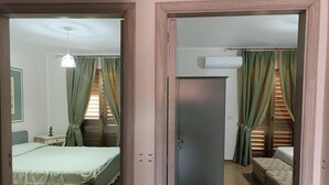 A room with a bed, a nightstand, a wardrobe, and a window with curtains. - Holiday Home in Giardini Naxos near Beach (Taormina Messina)