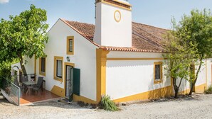 A white building with yellow trim and a tiled roof.