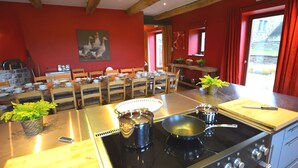 A kitchen with wooden chairs, a stove, and a dining table. - Holiday Home in Falaën with Garden BBQ (Stave)