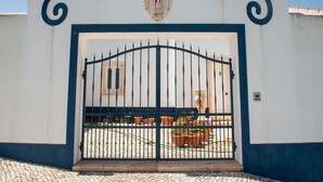 A gated entrance with a decorative arch and a relief sculpture above the door.