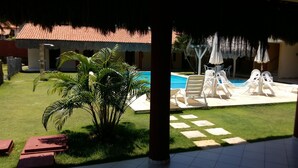 Ein Poolbereich mit Liegestühlen und einer Palme.