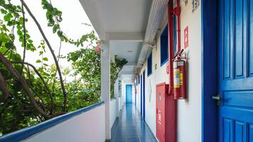 A corridor with blue doors, a fire extinguisher, and a number 15 sign.