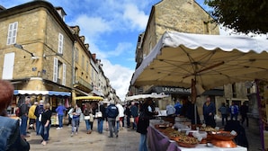 A bustling outdoor market with vendors and shoppers.