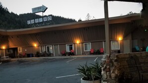 Un edificio con estacionamiento techado, mesas al aire libre y un letrero que indica un casino.