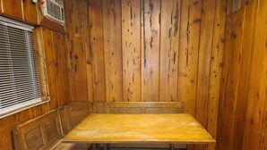 Una habitación de madera con una mesa grande y bancos.