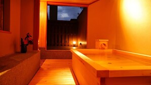 Un onsen japonés tradicional con suelos y banco de madera.