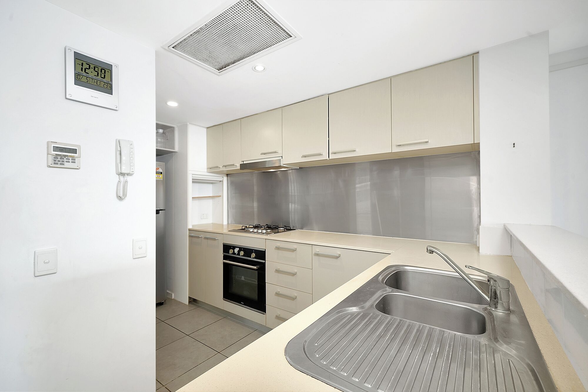 Una cocina moderna con horno empotrado, cocina a gas y pileta de acero inoxidable.