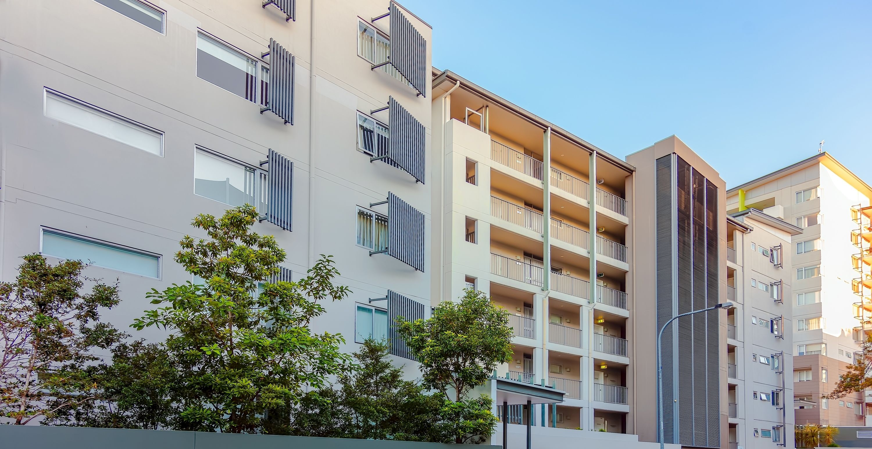 A multi-story residential building with balconies, large windows, and a modern architectural design.