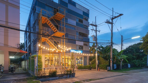 A multi-story hotel with a visible sign for 'BEDGASM'. - BEDGASM Hotel x Café at Nimman (Chiang Mai)