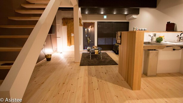 Een moderne keuken met houten vloeren, een centraal eiland en een trap naar een hoger niveau.