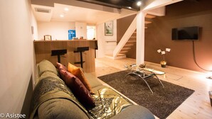 Een moderne woonkamer met een bank, een salontafel en een trap naar een hoger niveau.