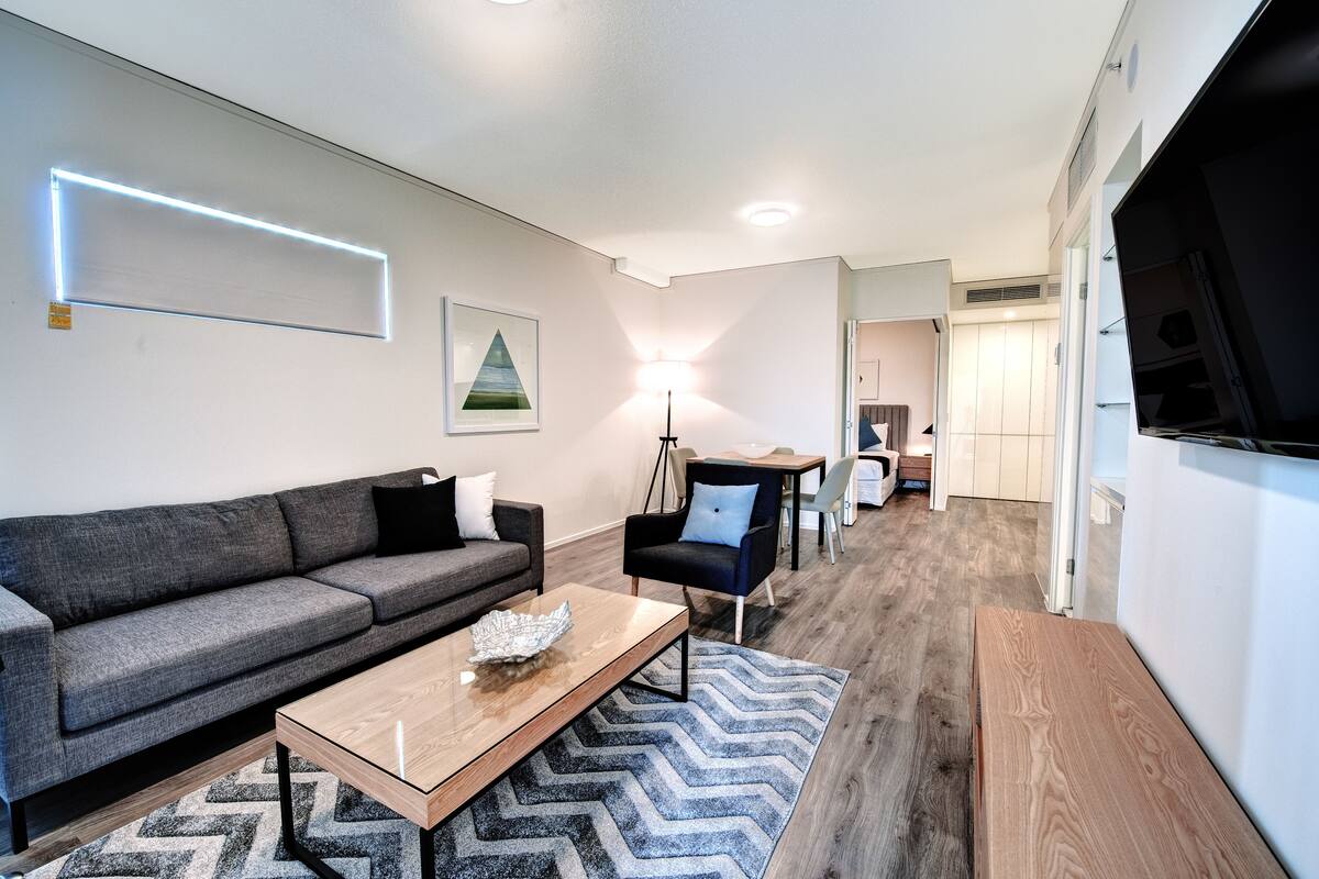A modern living room with a sofa, coffee table, and a lamp.