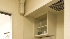 A compact kitchenette with a sink, stove, and a small refrigerator. - Aoi Hotel (Nagoya)
