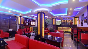 A modern hotel lobby with red seating, a reception desk, and a staircase leading to upper floors. - Hotel Gallery Nepal (Kathmandu)