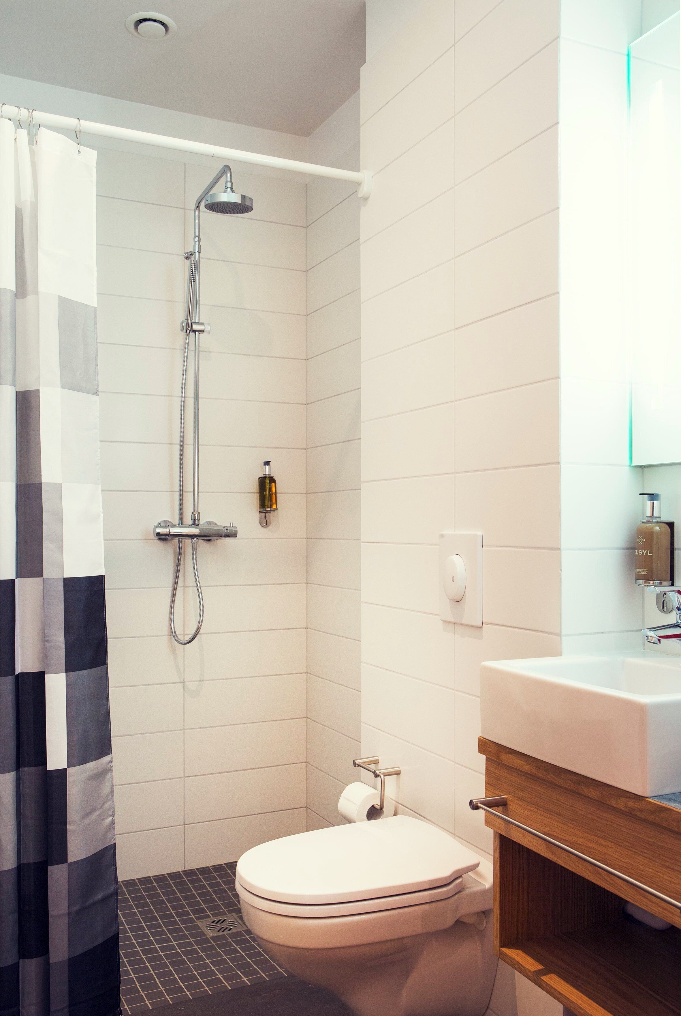A modern bathroom with a shower, toilet, and sink.
