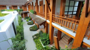 A modern hotel with a central courtyard, wooden balconies, and a mix of indoor and outdoor spaces. - Mount Inle Hotel & Resorts (Nyaungshwe)