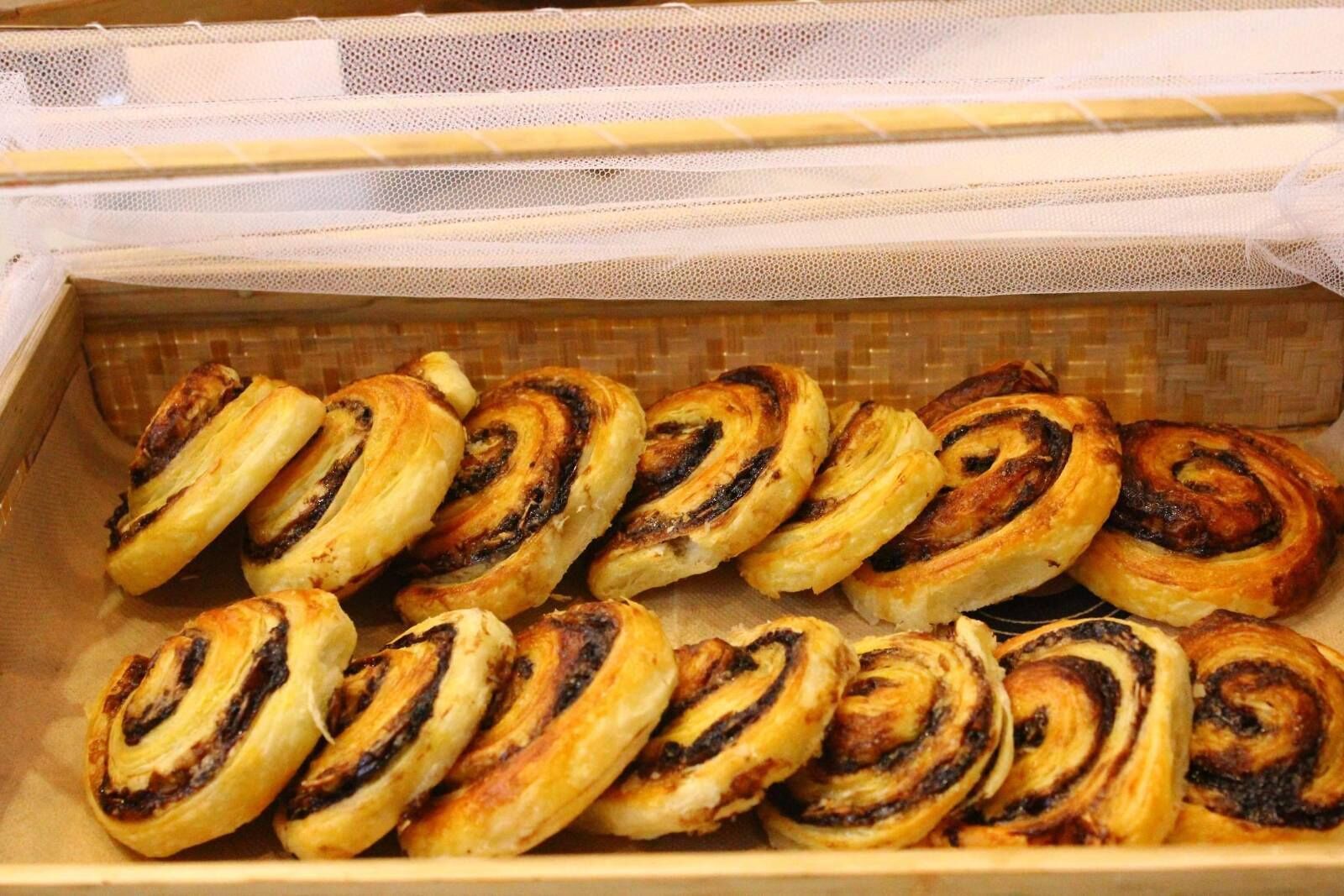 A tray of freshly baked cinnamon rolls in a bakery.