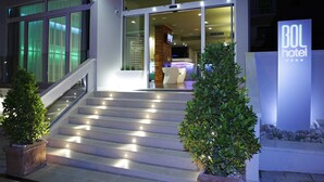 A hotel entrance with a staircase leading to the lobby, a sign reading "BOL hotel", and a well-lit interior visible through the glass doors. - Boutique Hotel Bol (Bol)